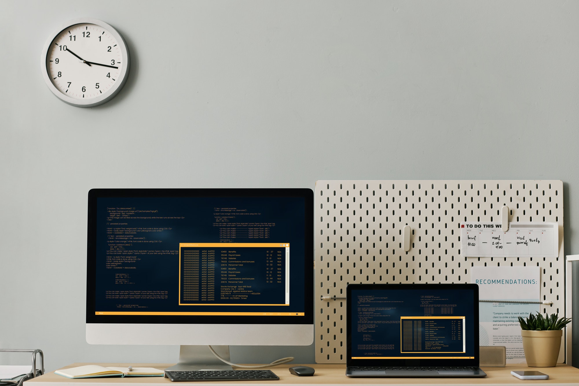 Office workplace setup with computer code on two screens